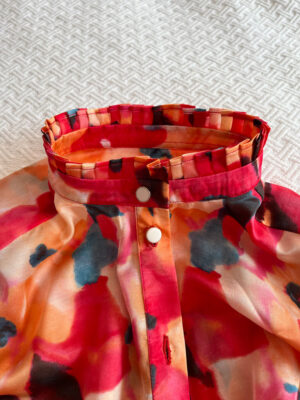 pleated stand collar on a silk printed blouse