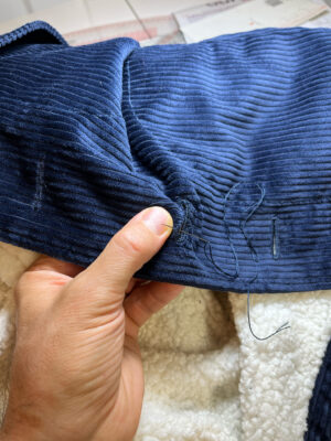 Hand stitched buttonholes on navy corduroy jacket